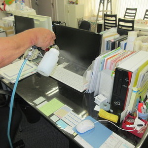 事務所のデスクにエコキメラによる抗ウイルス作業